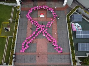 Integrantes de la U de G forman un gran listón rosa en memoria de quienes enfrentan el cáncer de mama - ZMG Noticias