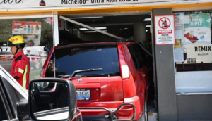 Una camioneta entró a un Oxxo quedando atorada en la puerta principal.